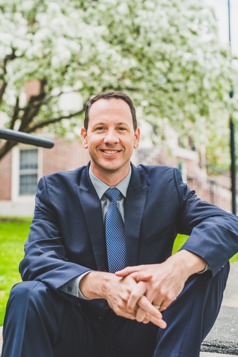 Mike Wisecup seated outdoors in a suit